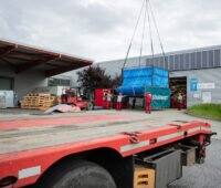 Container mit Laminatoren werden mit Kran in Modulproduktion von Solarwatt gebracht