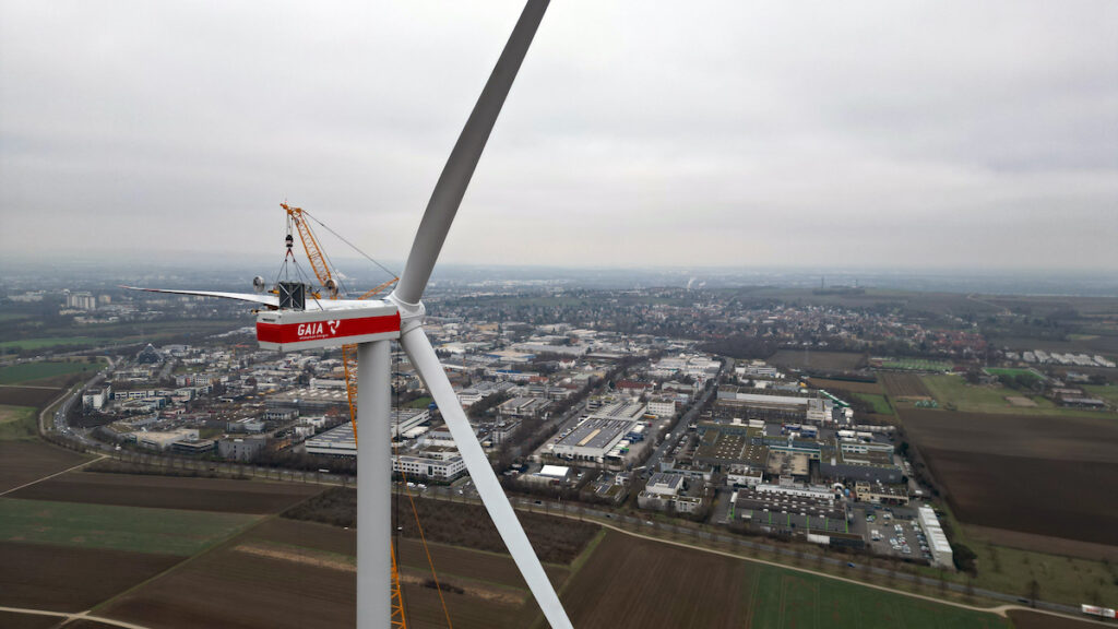 Mit Rotoren einer Windenergieanlage im Vordergrund Blick in Mainz aus der Vogelperspektive.