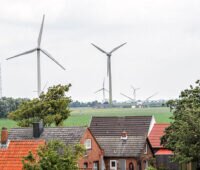 Windenergieanlagen in Norddeutschland hinter Gebäudedächern