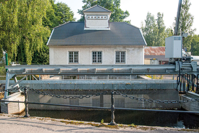 Kleines, historisches Wasserkraft mit Rechen im Vordergrund