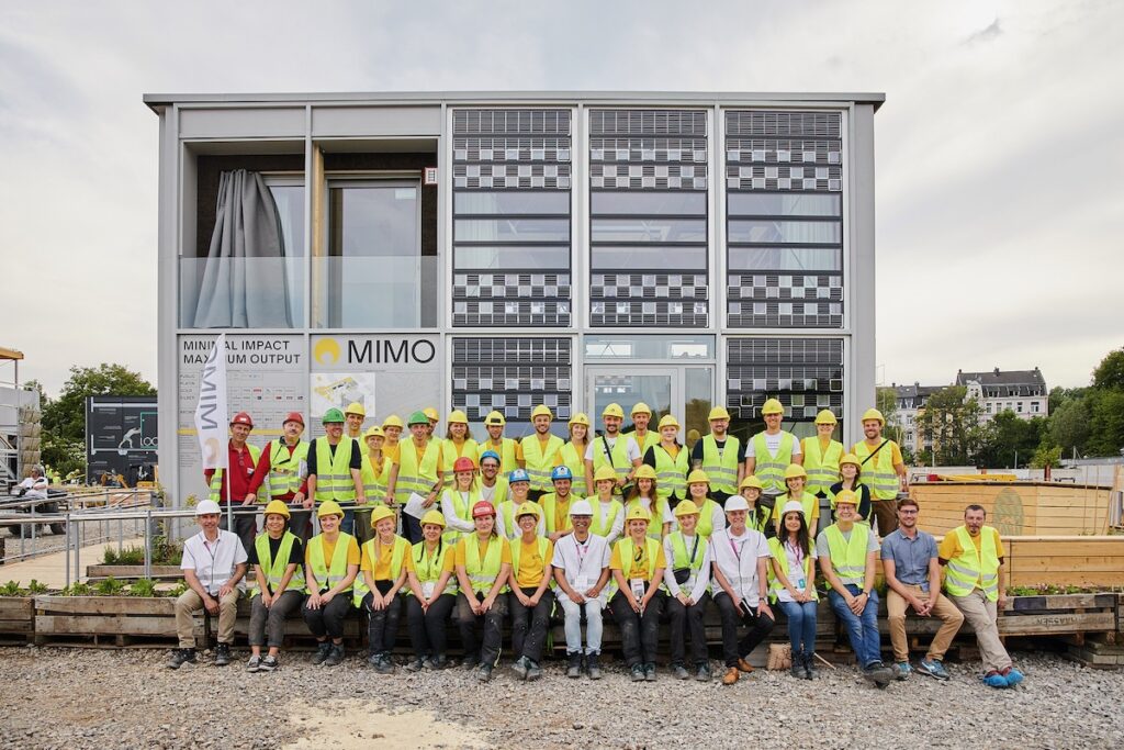 Gruppenfoto vor Solarhaus beim Solar Decathlon, Wettebewerb für Solar-Architektur