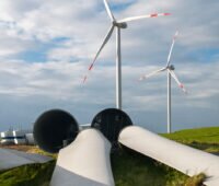 Im Vordegrund: abgebaute Teile von WIndenergieanlagen in einem repowerten Windpark (Hintergrund)