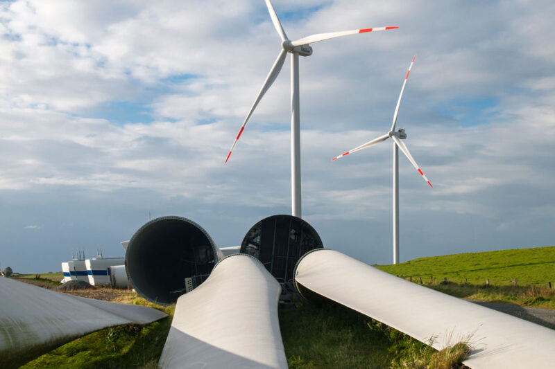 Im Vordegrund: abgebaute Teile von WIndenergieanlagen in einem repowerten Windpark (Hintergrund)