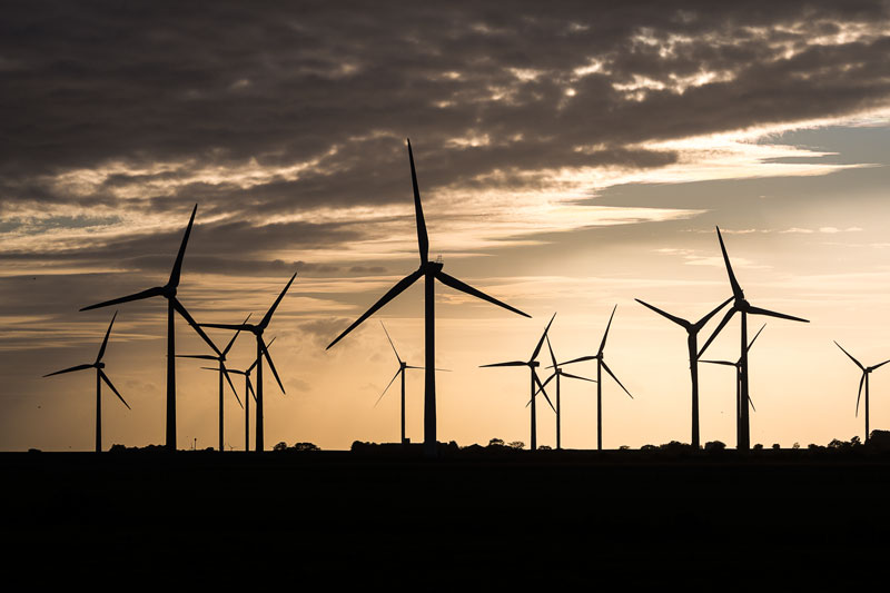 Windkraftwerke als Silhouette im Gegenlicht