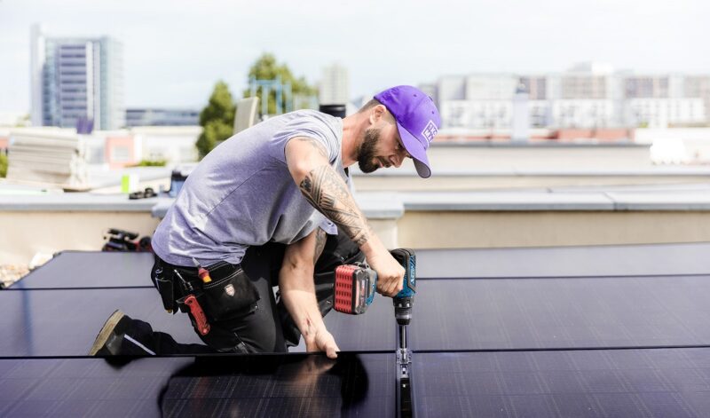 Im Bild ein Monteur, eine Photovoltaik-Anlage installiert, 1Komma5° hat den Solaranbieter Zonduurzaam gekauft.