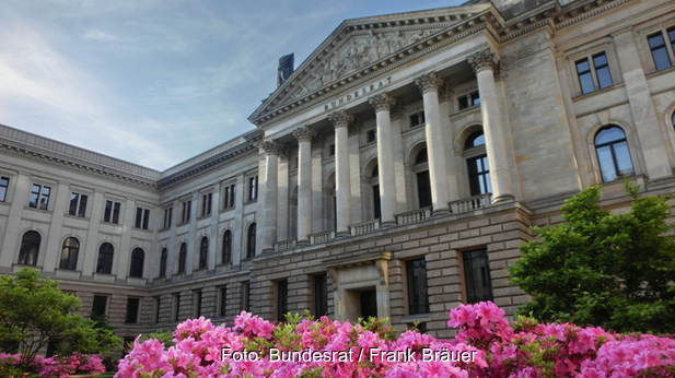 Zu sehen ist das Gebäude des Bundesrates mit pinken Blüten im Vordergrund