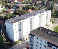 Luftbild einer Photovoltaikanlage auf dem Dach eines Wohnblocks