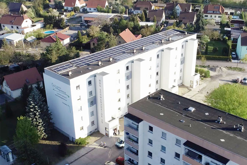 Luftbild einer Photovoltaikanlage auf dem Dach eines Wohnblocks