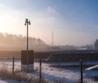 Mast mit energieautarker Überwachungskamera in einem Solarpark