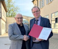 Handschlag zwischen Rektor der Hochschule Rottenburg, Bastian Kaiser, und Klaus Lambrecht auf dem Gelände der Hochschule Rottenburg