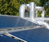 Solarthermieanlage vor Fernwärme-Leitungen