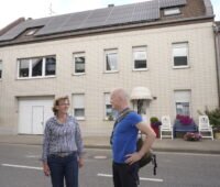 Eine Frau und ein Mann vor einem Haus mit Photovoltaik-Anlage, in Keyenberg.