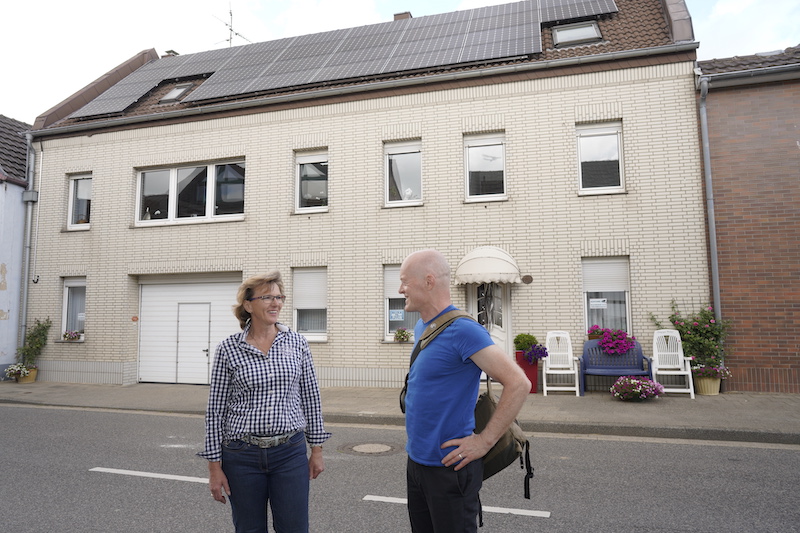 Eine Frau und ein Mann vor einem Haus mit Photovoltaik-Anlage, in Keyenberg.