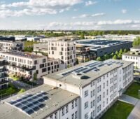 Luftaufnahme von Häuseblocks mit Photovoltaik-Anlagen - die Stadtwerke sind Zubau-Meister für Solarenergie in Berlin