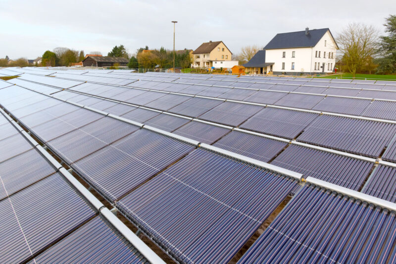 Solarthermieanlage für die Fernwärme in Lemgo. Im Hintergrund sieht man Wohnhäuser.