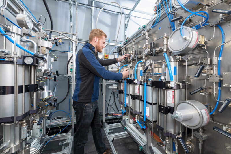 Ein TÜV-Mitarbeiter steht im Wasserstoff-Prüflabor.