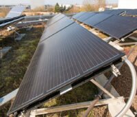 PVT-Kollektoren vom Typ Solink für eine Wärmepumpe auf einem begrünten Flachdach montiert.