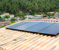 Steckersolargerät auf rotem Dach mit freiliegenden Anschlusskabeln