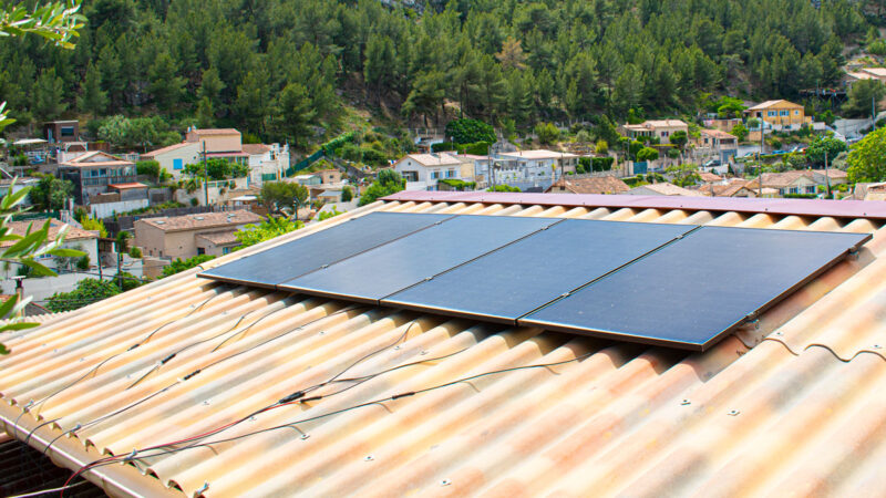 Steckersolargerät auf rotem Dach mit freiliegenden Anschlusskabeln