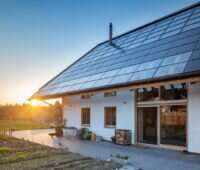 Einfamilienhaus mit PV auf Schrägdach bei Sonnenaufgang.