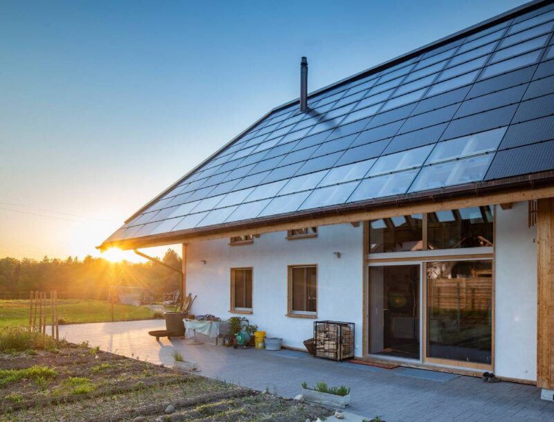 Einfamilienhaus mit PV auf Schrägdach bei Sonnenaufgang.