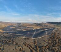 Ein Solarkraftwerk in karger bergiger Landschaft.