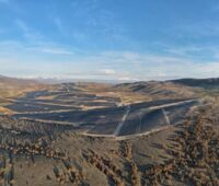 Ein Solarkraftwerk in karger bergiger Landschaft.