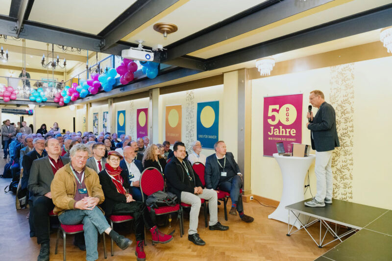 Festsaal mit Publikum und rechts dem Redner Frank Späte.