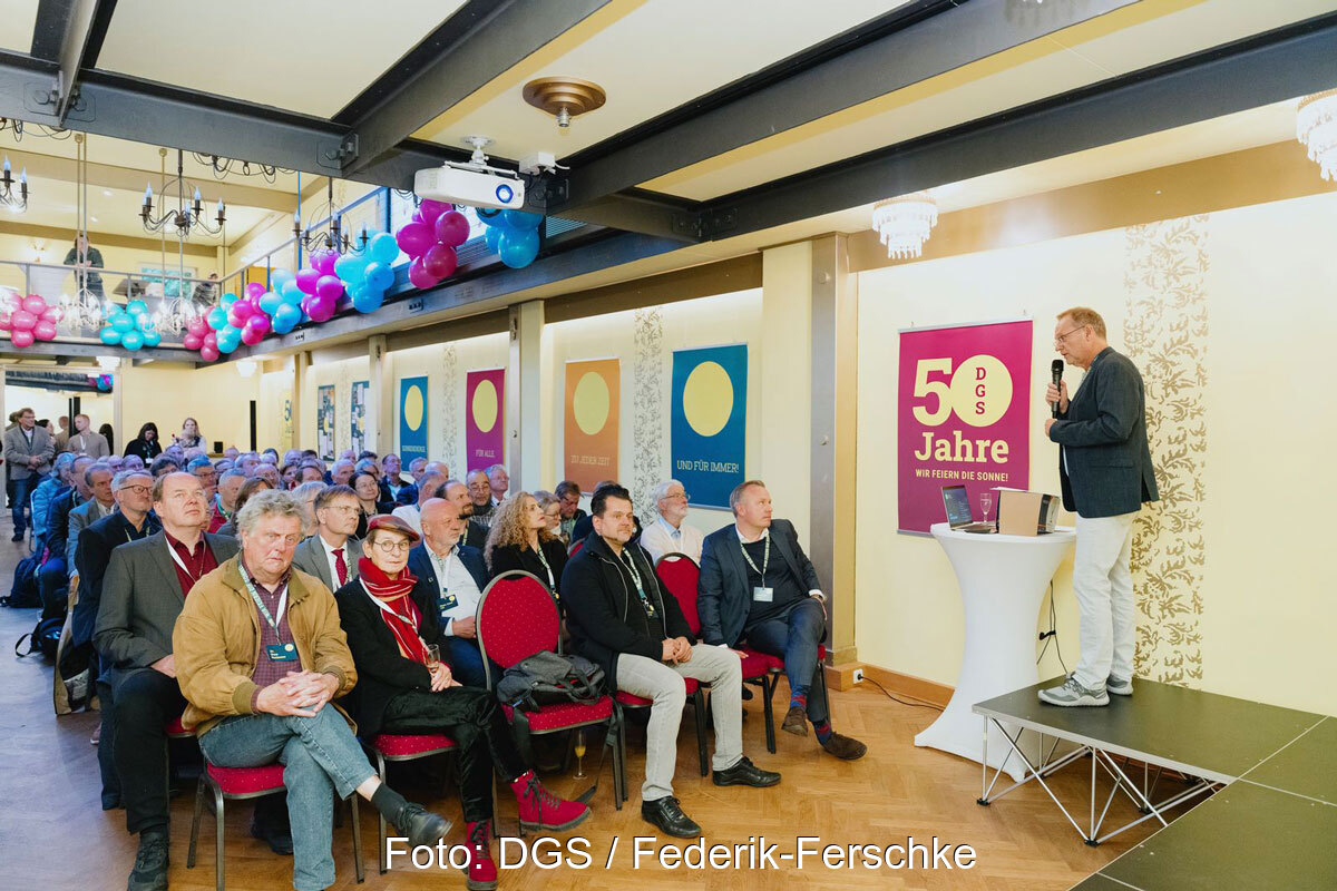 Festsaal mit Publikum und rechts dem Redner Frank Späte.