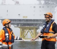 Im Bild zwei 50Hertz Mitarbeitende auf der Ostsee bei der Kontrolle der Offshore-Windenergie.