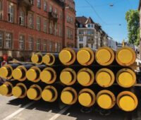 Ein Stapel Fernwärmerohre in einer Altstadt, das Bundesministerium für Wirtschaft und Energie (BMWE) legt Eckpunkte zur Novelle des Kraft-Wärme-Kopplungsgesetzes (KWKG) vor, um auch Wärmenetze zu stärken.