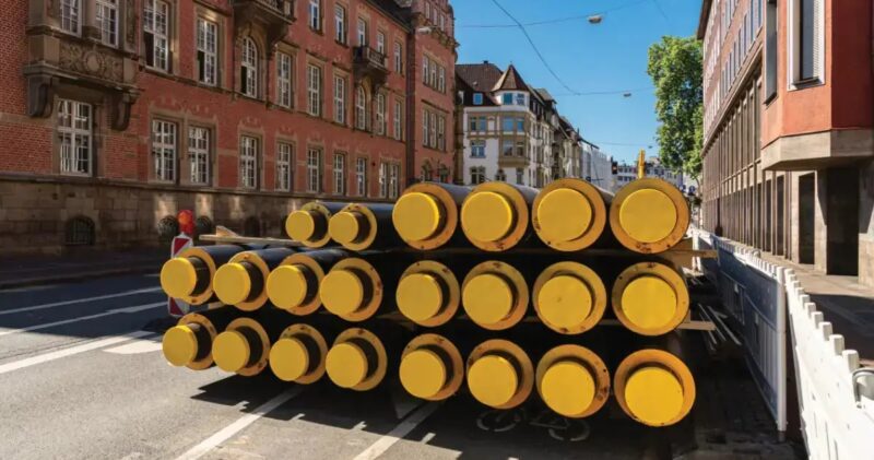 Ein Stapel Fernwärmerohre in einer Altstadt, das Bundesministerium für Wirtschaft und Energie (BMWE) legt Eckpunkte zur Novelle des Kraft-Wärme-Kopplungsgesetzes (KWKG) vor, um auch Wärmenetze zu stärken.