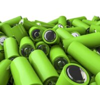 Zu sehen ist ein Haufen grüner Batterien als symbolische Darstellung für einen Energiespeicher aus Second-Life-Batterien.