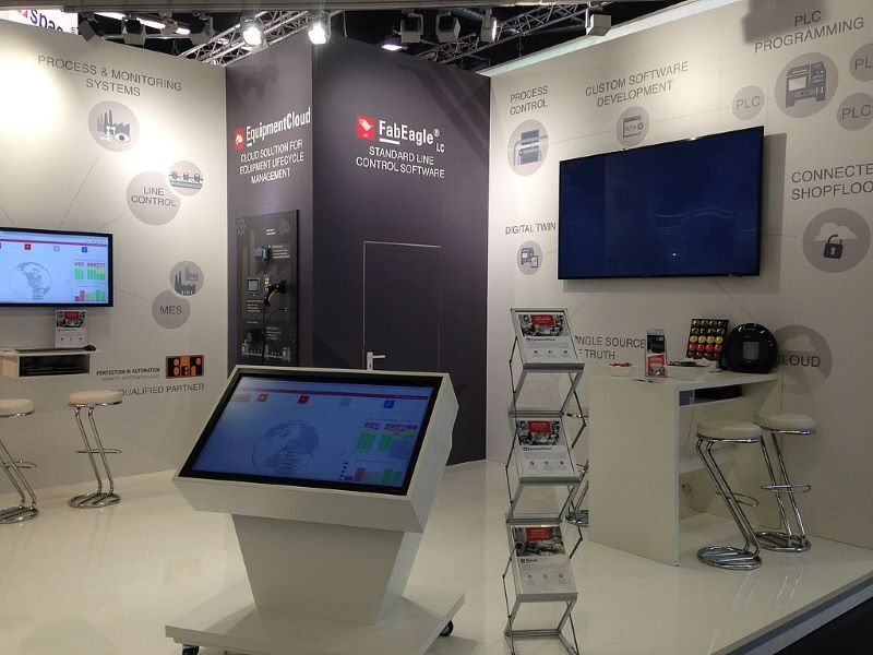 Ein Messestand mit Bildschirmen, Prospekten und Aufstellern zu IT-Produkten der Firma AIS Automation