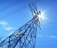 Blick auf einen Strommast von unten, wie stark Wärmepumpen künftig die Stromnetze belasten, hat das Fraunhofer IEE untersucht.