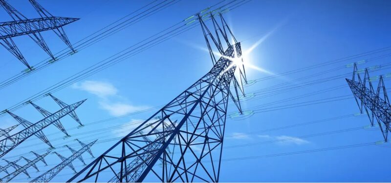 Blick auf einen Strommast von unten, wie stark Wärmepumpen künftig die Stromnetze belasten, hat das Fraunhofer IEE untersucht.