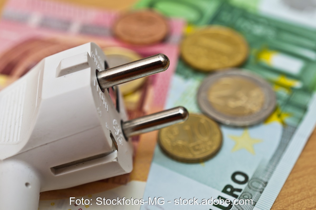 Zu sehen ist ein symbolisches Bild mit Geldscheinen und einem Stromstecker zur Illustration der Absenkung der EEG-Umlage.