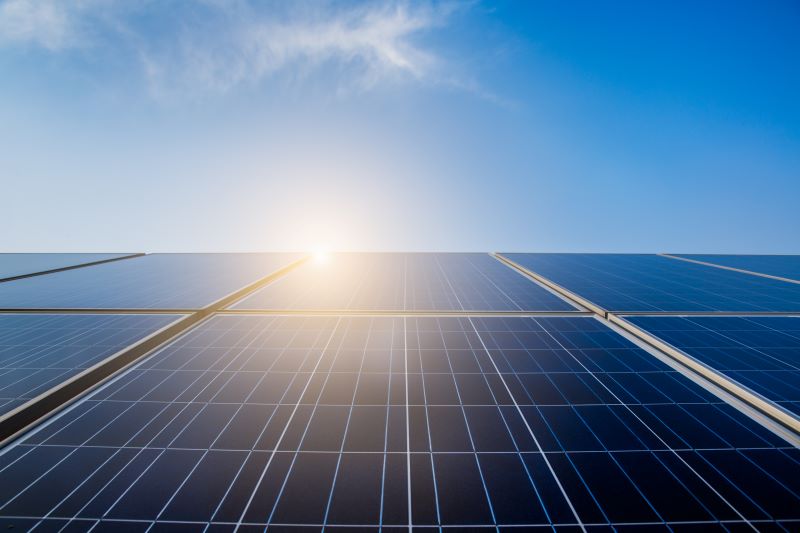 Photovoltaik-Module unter blauem Himmel mit strahlender Sonne, Solaranlagen