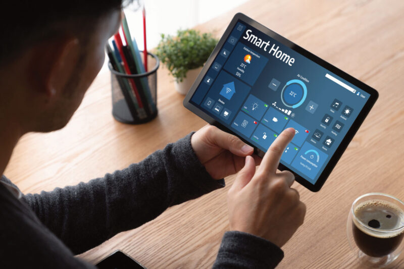 Jemand bedient ein Heim-Energiemanagementsystem HEMS auf dem iPad