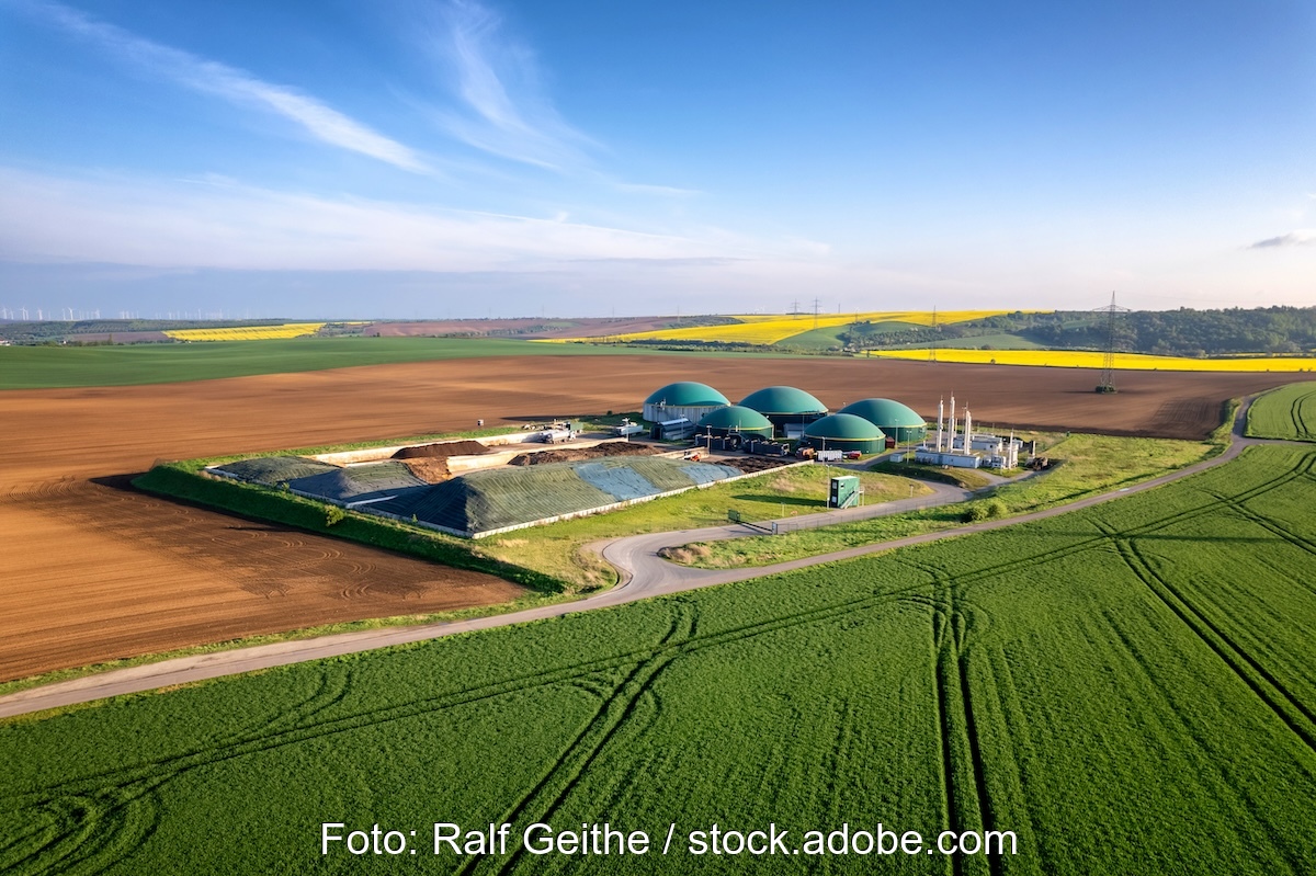 In einer Feldlandschaft steht eine Biogasanlage. Bei Aufbereitung von Biogas zu Biomethan, kann es auch in Gasheizungen zum Einsatz kommen.