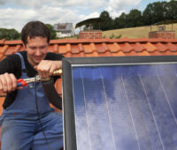 Installateur montiert Solarthermie-Anlage