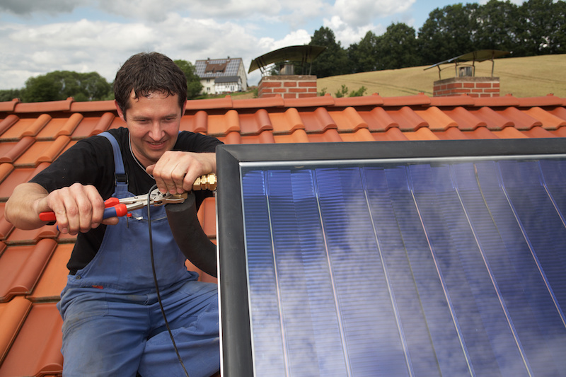 Installateur montiert Solarthermie-Anlage
