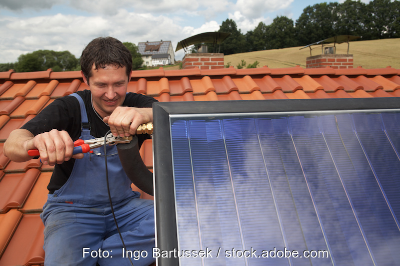 Installateur montiert Solarthermie-Anlage