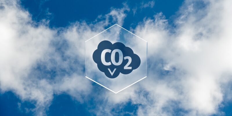 Die Aufschrift CO2 vor einem Himmel mit leichten Wolken als Symbol für Direct Air Capture, der Abscheidung von CO2 aus der Luft.