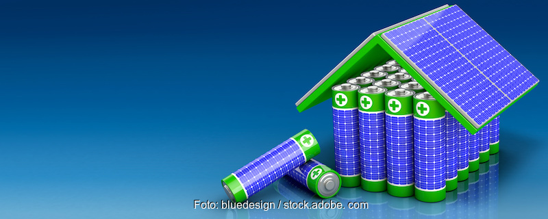 Ein symbolisches Bild: auf einer blauen Fläche aufgestellte Batterien, die von angedeuteten PV-Modulen überdacht werden.