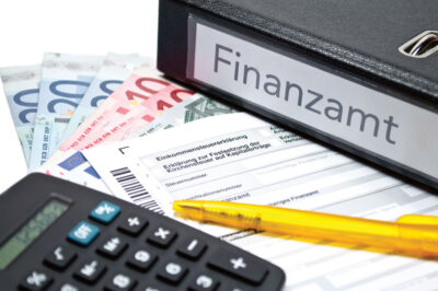 Schreibtischablage mit Taschenrechner und Leitz-Ordner "Finanzen" - Symbolbild für Jahressteuergesetz