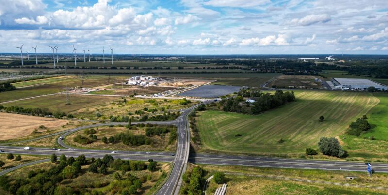 Luftaufnahme von Windenergieanlagen und Freiflächen-Photovoltaik an einer Autobahn, in Netzengpassgebieten soll der Ausbau von Wind und Solar eingeschränkt werden.