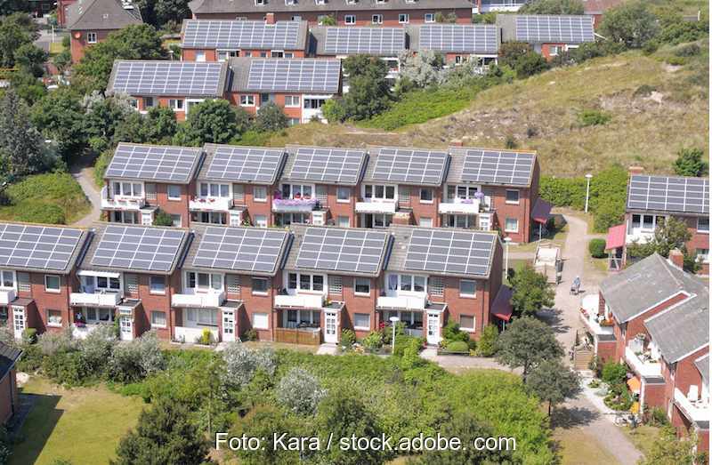 Eine Gebäudesiedlung mit Solarmodulen auf den Dächern.