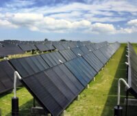 Eine Reihe von Solarthermie-Kollektoren auf einer WIese - Solarthermie statt Strom