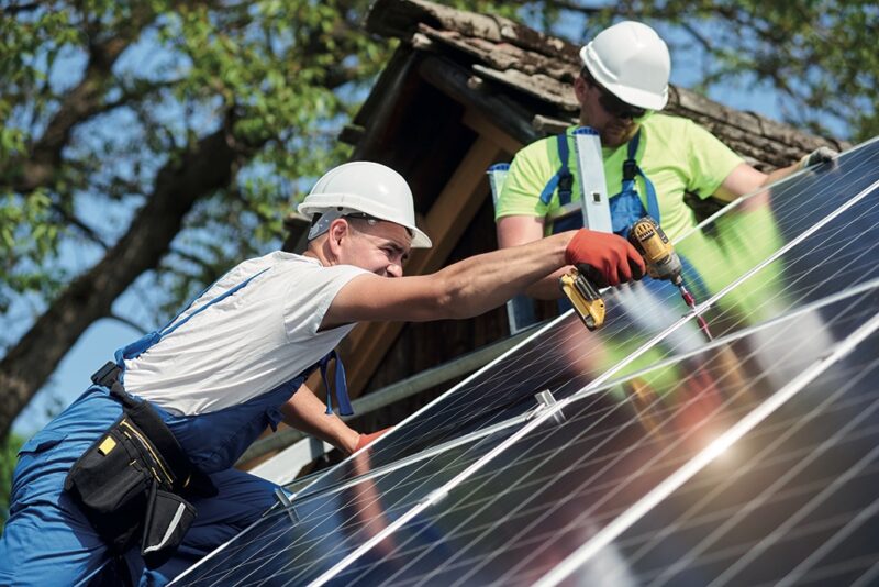 Zwei Handwerker installieren eine Photovoltaik-Anlagek